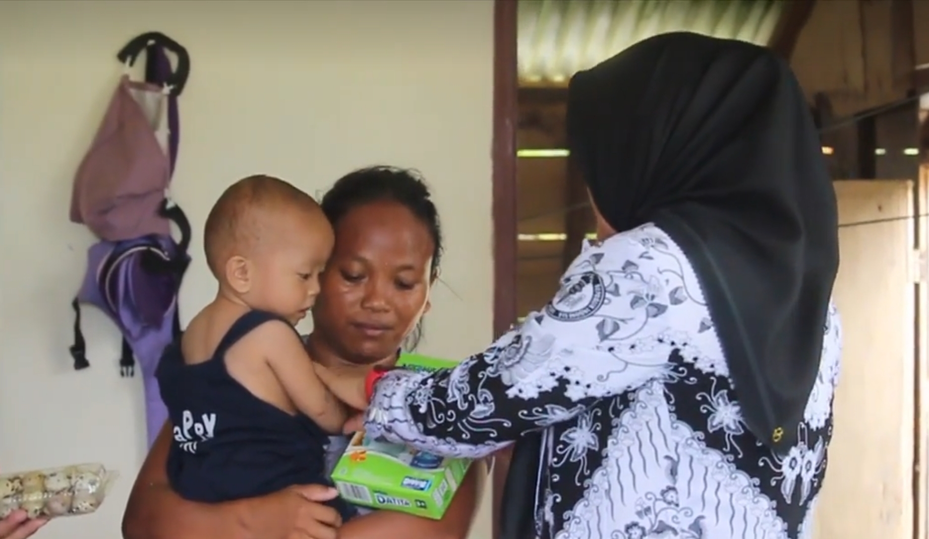 Kadis Pendidikan menyerahkan bantuan kepada ibunda dari anak terdampak stunting di Kecamatan Bolaang Uki.