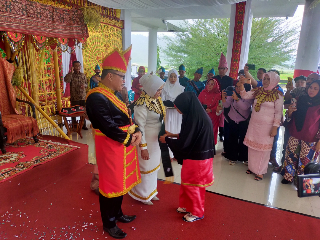 Budayawan perempuan Peong, memakaikan salempang kepada istri Bogani Limi, Boki Iryanti.