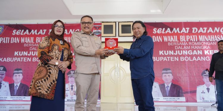 Bupati Ir Limi Mokodompit didampingi Ketua TP PKK Bolmong, menyerahkan cendramata kepada Bupati James Sumendap.